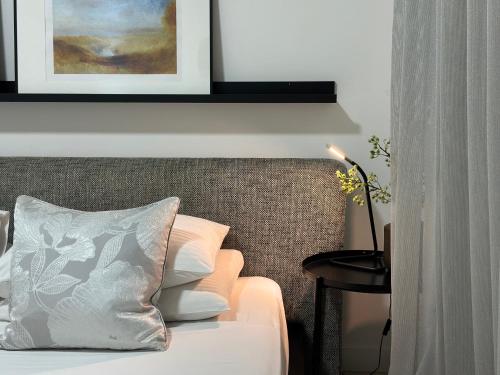 a bedroom with a bed with a pillow and a table at Modern City Apartment in Larnaka