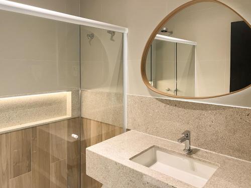 a bathroom with a sink and a mirror at Marino Beach Hotel in Cabo Frio