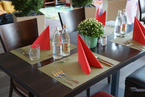 a wooden table with red napkins and forks and knives at Holiday Inn Express Zürich Airport by IHG in Rümlang