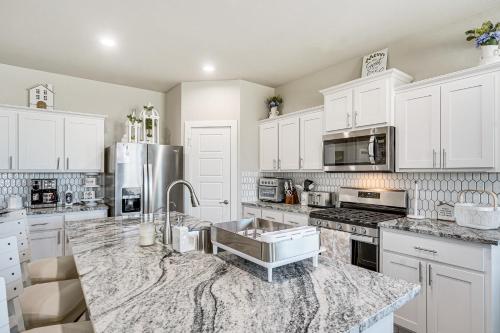 a kitchen with white cabinets and a marble counter top at Spacious Family Home with Office in Midland-Odessa! in Midland
