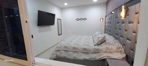 a bedroom with a bed and a flat screen tv at Hotel y Cabañas Parinzzi in Guatapé
