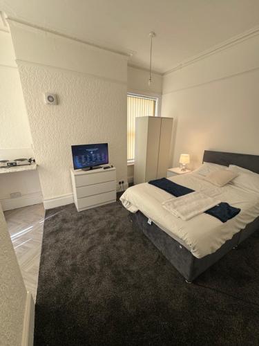 a bedroom with a bed and a flat screen tv at The Cozy House in Wolverhampton