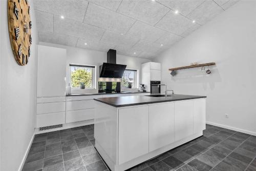a kitchen with white cabinets and a black counter top at BV144-Blavand-Horntoftvej-13 in Blåvand