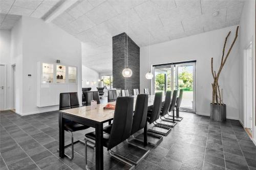 a dining room with a table and black chairs at BV144-Blavand-Horntoftvej-13 in Blåvand