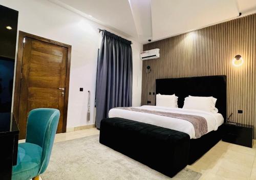 a bedroom with a large bed and a blue chair at De Fivez in Lagos