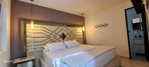a bedroom with a large white bed in a room at Hotel y Cabañas Parinzzi in Guatapé