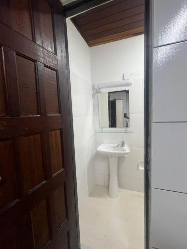 a bathroom with a sink and a mirror and a door at Casa da Ceiça in Belém