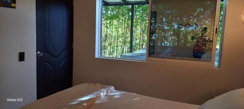 a bedroom with a window and a bed and a mirror at Hotel y Cabañas Parinzzi in Guatapé
