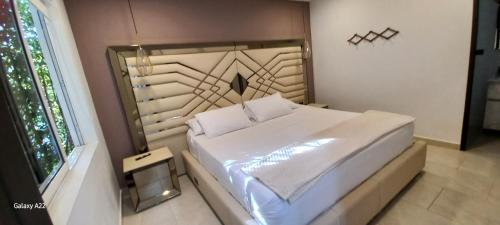 a white bed in a room with a window at Hotel y Cabañas Parinzzi in Guatapé