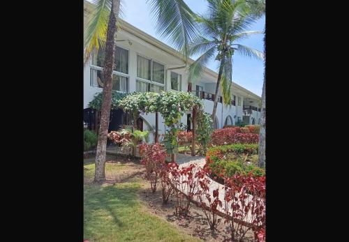 a building with a bunch of flowers in front of it at Modo relax Quepos in Quepos