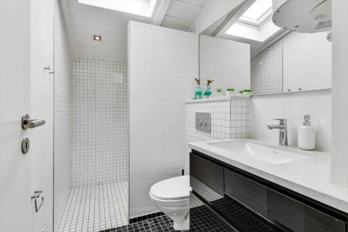 a white bathroom with a toilet and a sink at BV339-Blavand-Toldbodvej-28 in Blåvand