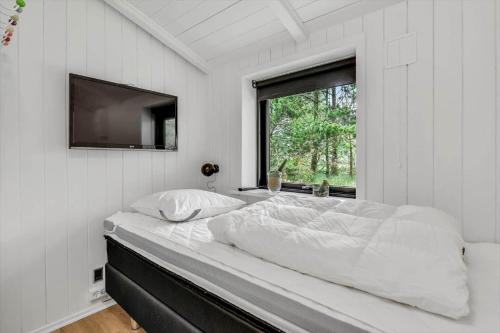 a white bedroom with a large bed and a window at BV339-Blavand-Toldbodvej-28 in Blåvand
