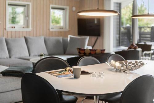 a living room with a table and chairs and a couch at BV313-Blavand-Hvidbjerg-Strandvej-40 in Blåvand