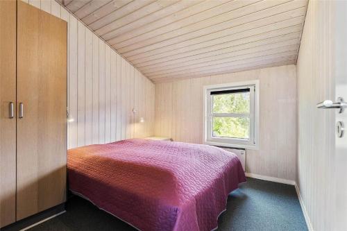 a bedroom with a bed in a room with a window at BV157-Blavand-Gronnevaenget-11 in Blåvand