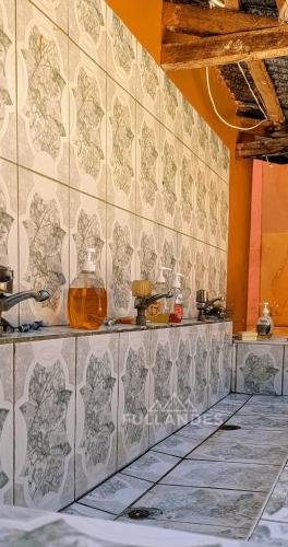 a kitchen with a tiled wall with a counter at Amantani sol Andino in Amantani