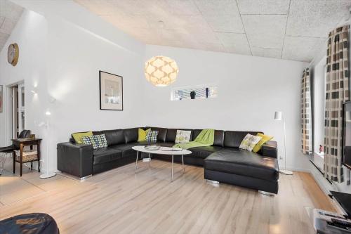 a living room with a black couch and a table at BV269-Blavand-Hvidbjerg-Strandvej-25-A in Blåvand