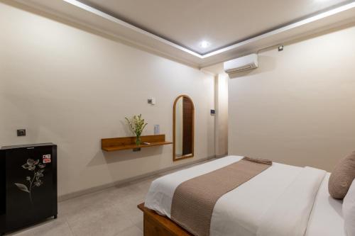 a bedroom with a bed and a mirror on the wall at Sandat Living in Canggu