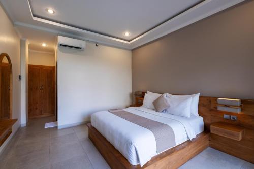 a bedroom with a large bed with white sheets at Sandat Living in Canggu