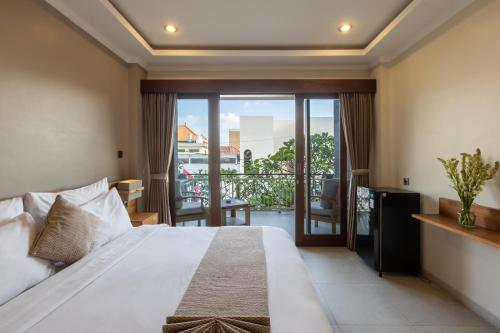 a bedroom with a bed and a balcony at Sandat Living in Canggu