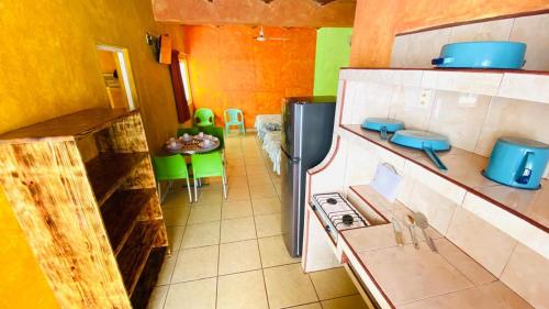 a kitchen with a refrigerator and a table with chairs at Bungalows El Rincon de La Riviera in Rincon de Guayabitos