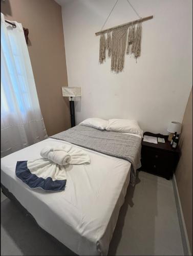 a bedroom with a bed with a towel on it at Casa De Shangrila in Belize City
