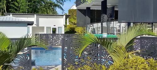 a house with a swimming pool and palm trees at Hotel y Cabañas Parinzzi in Guatapé