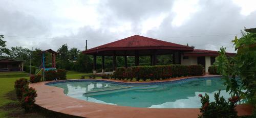 a swimming pool with a gazebo in a yard at Arenals Peak Villas in Agua Azul