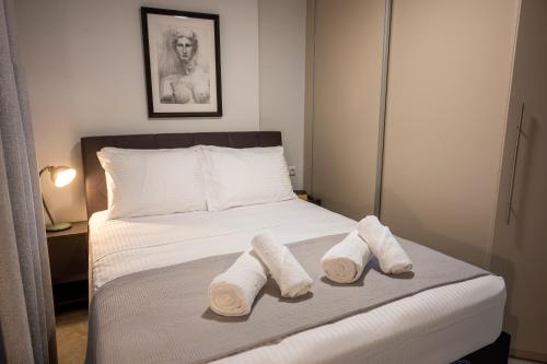 a bedroom with a bed with towels on it at The Circle Point Apartment in Larisa