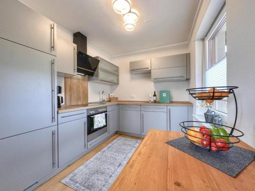 a kitchen with white cabinets and a bowl of fruit on a wooden table at Hochfels in Stadlern