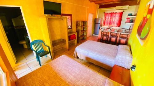 a small bedroom with a bed and a kitchen at Bungalows El Rincon de La Riviera in Rincon de Guayabitos