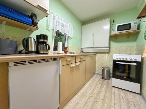a kitchen with white appliances and a wooden floor at Knusperhäuschen in Waldau