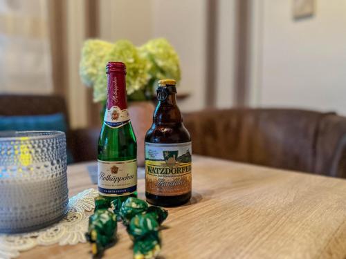 two bottles of beer sitting on a wooden table at Knusperhäuschen in Waldau