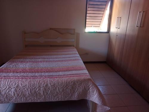 a bedroom with a bed with a bedspread on it at Casa disponível para esse final de semana, Barramar House in Barra de São Miguel
