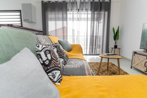 un salon avec un lit et un canapé dans l'établissement Le Nid de Thalys - Charming Apartment, à Cayenne
