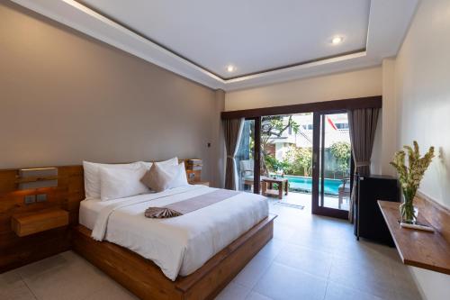 a bedroom with a large bed and a balcony at Sandat Living in Canggu
