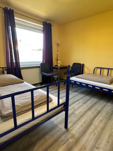a room with two bunk beds and a table at Hostel Pinneberg in Pinneberg