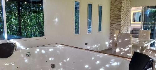 a large white bath tub in a room with windows at Hotel y Cabañas Parinzzi in Guatapé