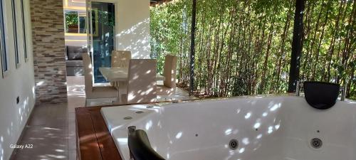 a white bath tub in a bathroom with a window at Hotel y Cabañas Parinzzi in Guatapé