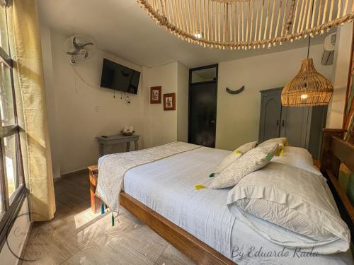 a bedroom with a bed and a television in it at Hostal Antawara Tayrona in El Zaino