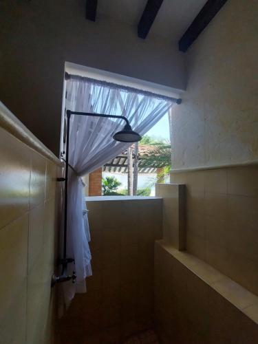 a bathroom with a shower with a curtain and a window at Espectacular Casa en Cauca viejo con piscina, jacuzzi y turco in Jericó