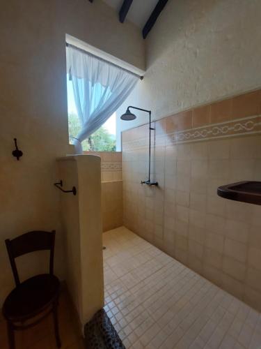 a bathroom with a shower with a window and a chair at Espectacular Casa en Cauca viejo con piscina, jacuzzi y turco in Jericó