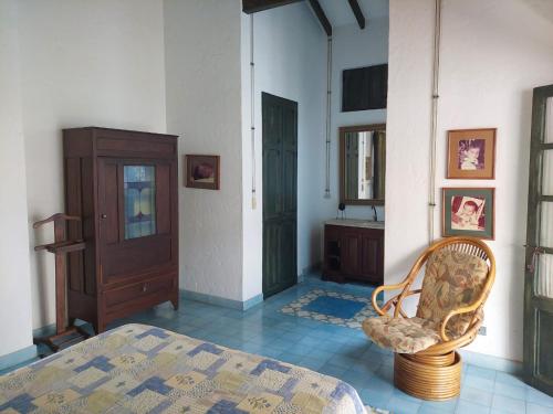 a bedroom with a bed and a cabinet and a chair at Espectacular Casa en Cauca viejo con piscina, jacuzzi y turco in Jericó