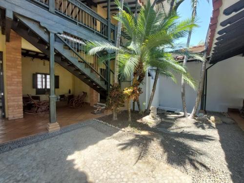 a courtyard with palm trees and a staircase at Espectacular Casa en Cauca viejo con piscina, jacuzzi y turco in Jericó