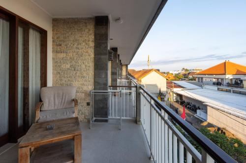 a balcony with a chair on a building at Sandat Living in Canggu