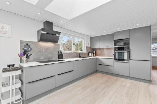 a kitchen with white cabinets and a large window at BV276-Blavand-Sonder-Vasevej-150 in Blåvand