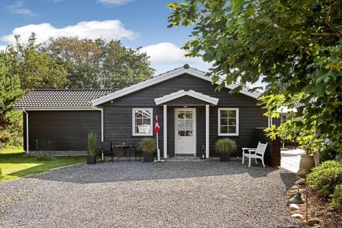 a black house with a gravel driveway at BV276-Blavand-Sonder-Vasevej-150 in Blåvand
