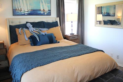 a bedroom with a large bed with a blue blanket at 1st Row, Unobstructed Gulf Views, Pet-Friendly! in Freeport