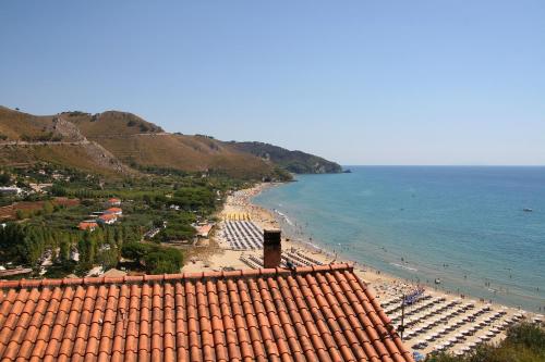 a view of a beach with chairs and the ocean at Hotel Corallo Sperlonga in Sperlonga