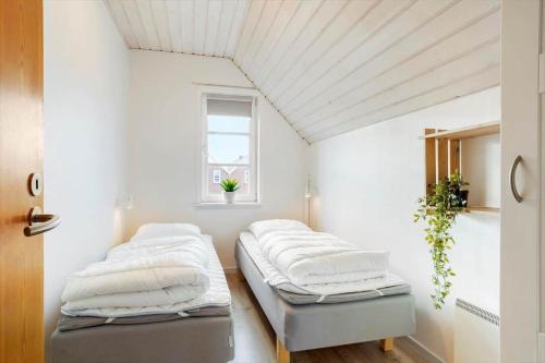 two beds in a white room with a window at 0440-Romo-Vestergade-227-Ap-17 in Sønderby