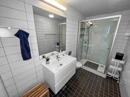 een witte badkamer met een wastafel en een douche bij 0387-Romo-Nordre-Havnevej-18 in Havneby